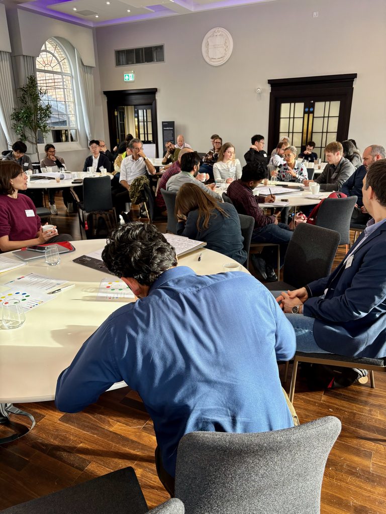 Individuals sat at round table involved in discussions.